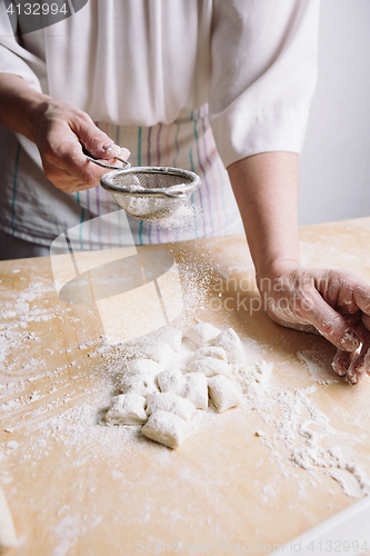 Image of Two hands making dough for meat dumplings.