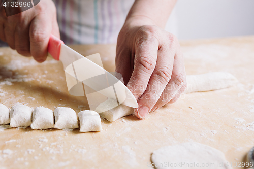 Image of Two hands making dough for meat dumplings.