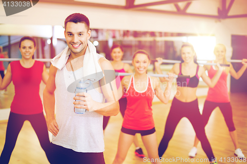 Image of smiling trainer in front of group of people