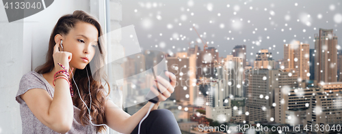 Image of teenage girl with smartphone and earphones