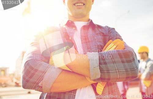 Image of close up of smiling builder hands in gloves