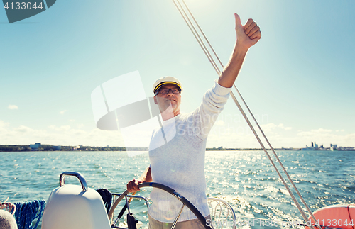 Image of senior man at helm on boat or yacht sailing in sea