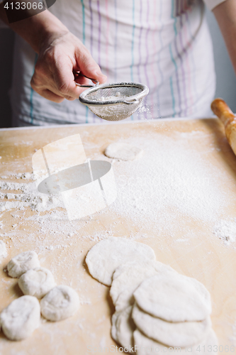 Image of Two hands making dough for meat dumplings.