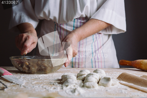 Image of Two hands making meat dumplings.