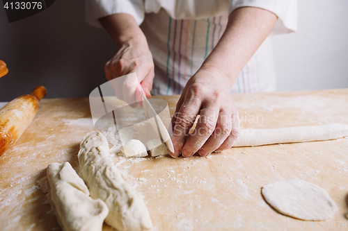 Image of Two hands making dough for meat dumplings.