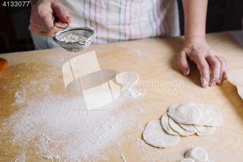 Image of Two hands making dough for meat dumplings.