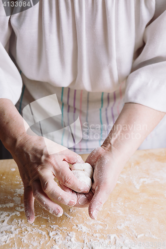 Image of Two hands making meat dumplings.