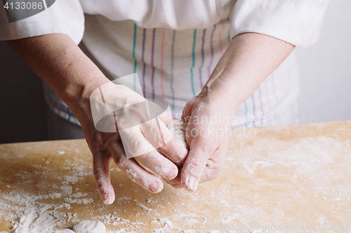 Image of Two hands making meat dumplings.