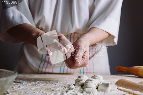 Image of Two hands making dough for meat dumplings.