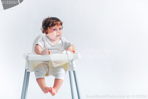 Image of Happy baby boy sitting on studio background