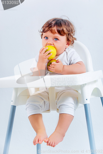 Image of Happy baby boy sitting and eating