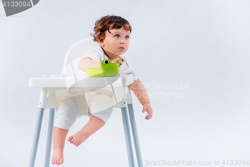 Image of Happy baby boy sitting on studio background