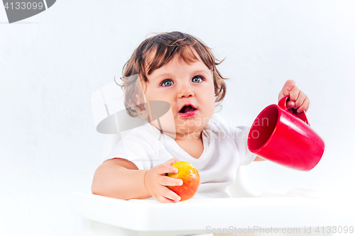 Image of Happy baby boy sitting and eating