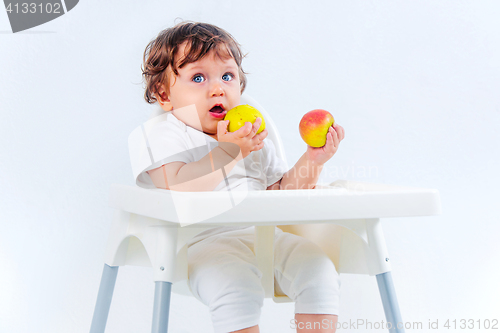 Image of Happy baby boy sitting and eating