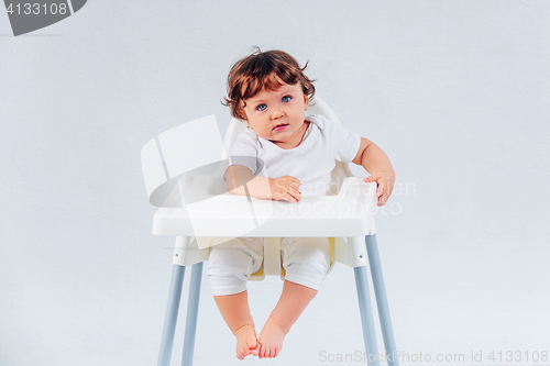 Image of Happy baby boy sitting on studio background