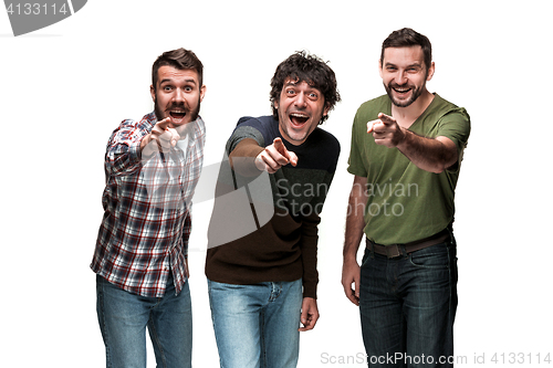 Image of The three men are smiling, looking and pointing at camera