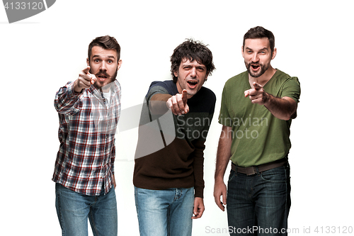 Image of The three men are smiling, looking and pointing at camera