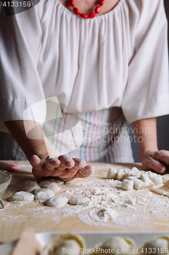 Image of Two hands making dough for meat dumplings.