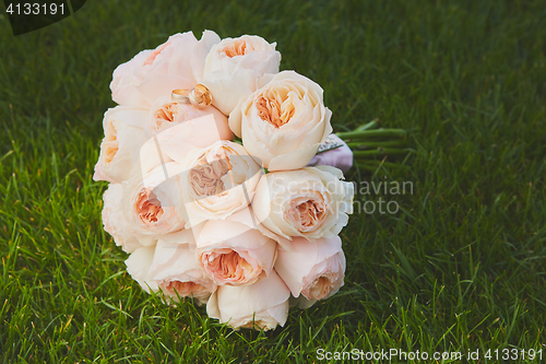 Image of wedding bouquet of the bride at the grass.