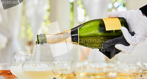 Image of Pouring champagne in flutes standing on table