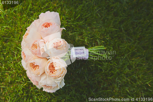 Image of wedding bouquet of the bride at the grass.