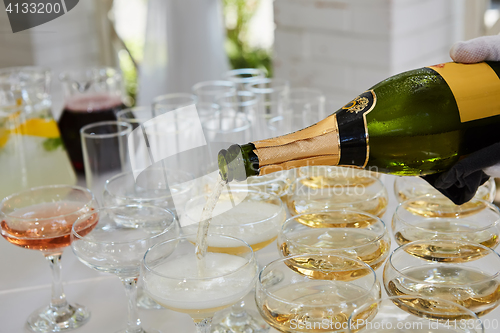 Image of Pouring champagne in flutes standing on table