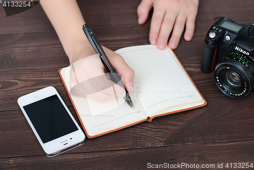 Image of Top view of a hands with pen and notepad