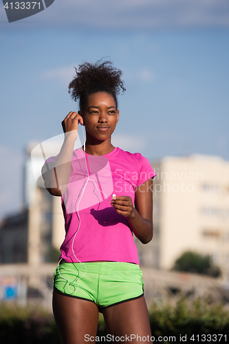 Image of young african american woman running outdoors