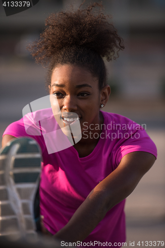 Image of African American woman doing warming up and stretching