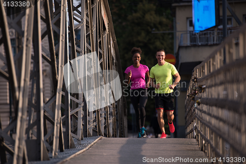 Image of multiethnic couple jogging in the city