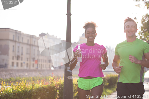 Image of young multiethnic couple jogging in the city