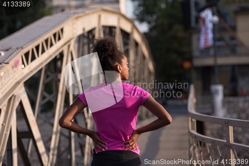 Image of african american woman running across the bridge