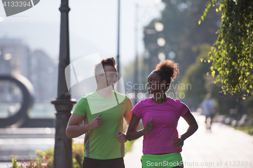 Image of young multiethnic couple jogging in the city