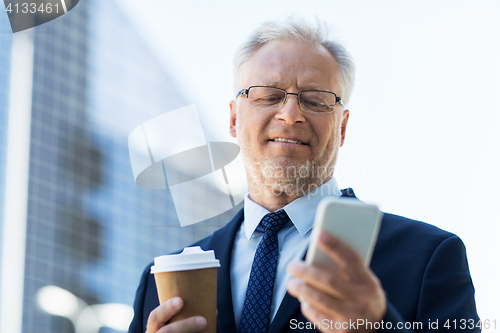 Image of businessman with smartphone and coffee in city