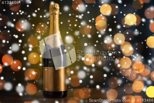 Image of bottle of champagne with golden label over snow