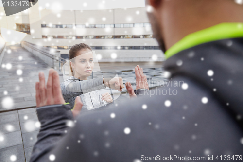 Image of woman with trainer working out self defense strike