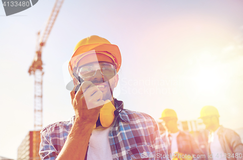 Image of builder in hardhat with walkie talkie