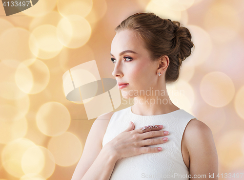 Image of smiling woman in white dress with diamond jewelry