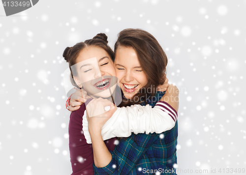 Image of happy smiling teenage girls hugging over snow