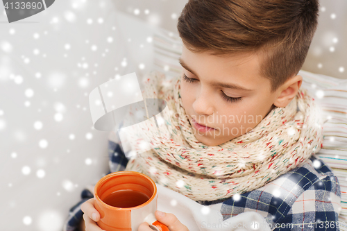 Image of close up of ill boy with flu drinking tea at home