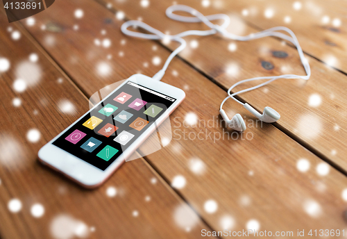 Image of close up of smartphone and earphones on wood