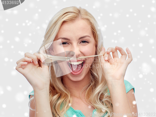 Image of happy young woman making mustache with her hair