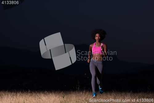 Image of Young African american woman jogging in nature