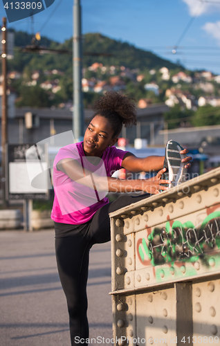 Image of African American woman doing warming up and stretching
