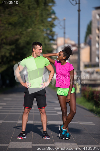 Image of portrait of young multietnic jogging couple ready to run