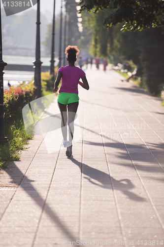 Image of african american woman jogging in the city