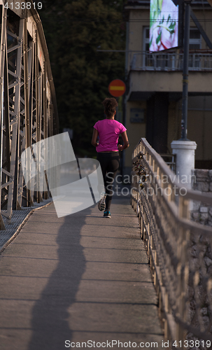 Image of african american woman running across the bridge