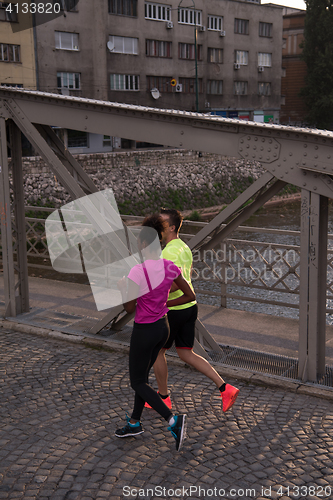 Image of young multiethnic couple jogging in the city