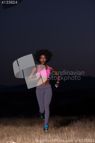 Image of Young African american woman jogging in nature