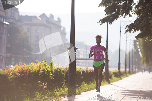 Image of african american woman jogging in the city